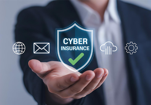 Hand holding a cyber insurance shield icon with technology symbols