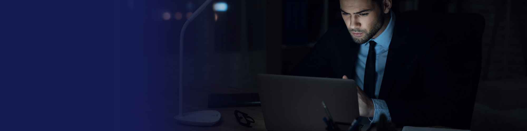 Businessman working on a laptop in a dark office at night