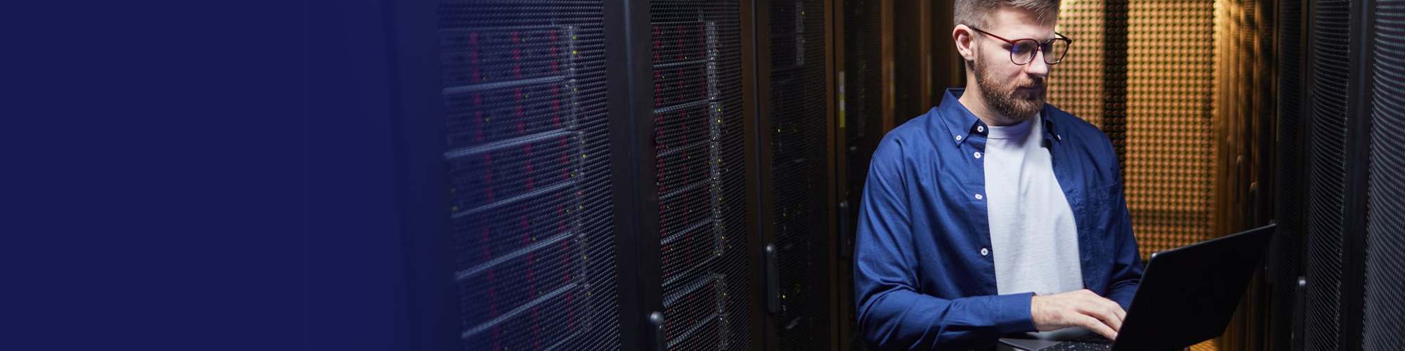 IT engineer working on a laptop in a server room
