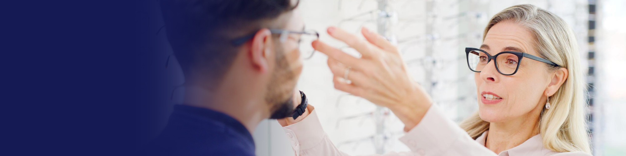 Optometrist fitting eyeglasses on a patient