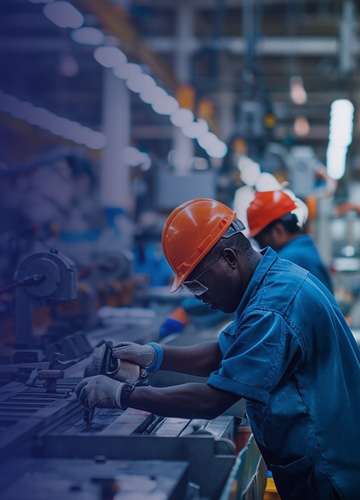 Factory worker in a hard hat operating machinery on a production line