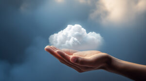 Open hand holding a small cloud against a blue sky