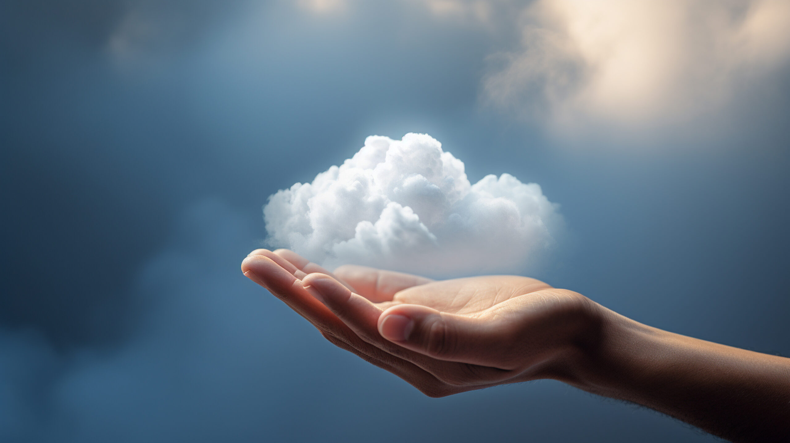 Open hand holding a small cloud against a blue sky
